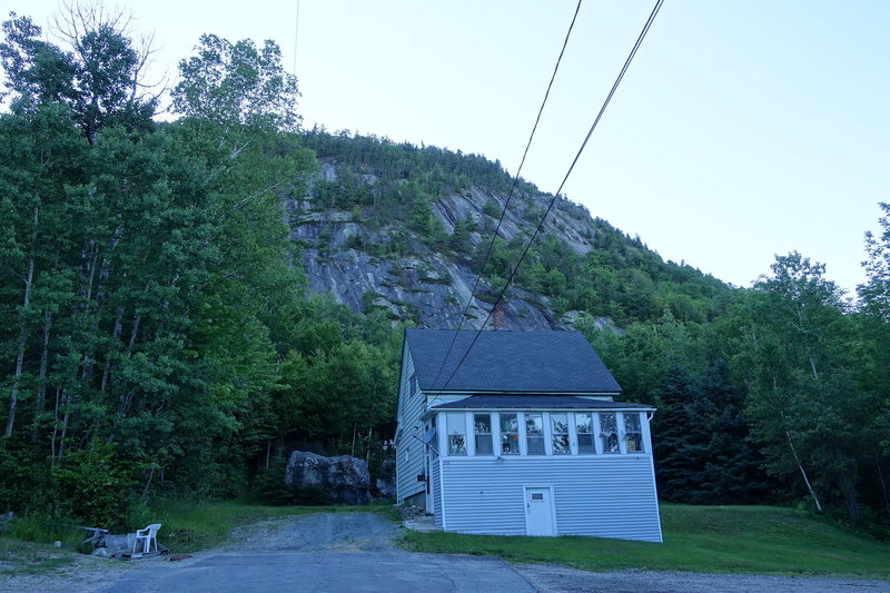 The approach trail (left of the boulder) and the cliff in the background.