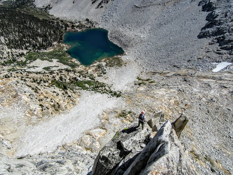 Neil Kauffman enjoying the exposure on P5 of the North Buttress. Third Recess Lake below.
