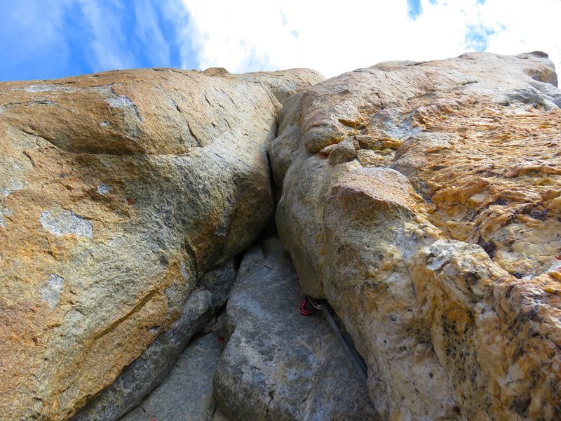 Looking up at the start of Pitch 2. This is the crux of the pitch but the feet are good and there is a piton just above the bulge that you can clip before making a committing move if you know to look for the piton. But the piton is old, so I backed it up with a 0.75 cam.