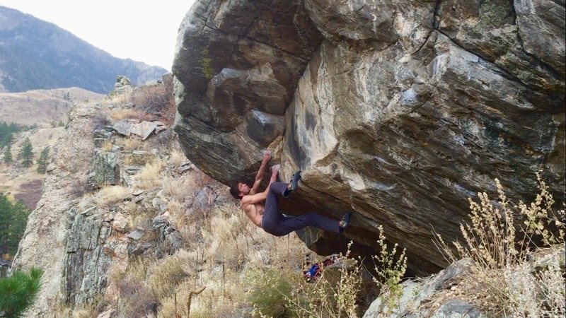 Setting up for the crux move after climbing out of the roof.