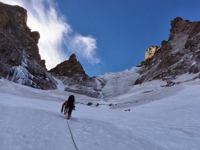 Halfway up the climb. The route takes the left couloir to reach the East Col. Aiguille du Pelvoux is the prominent spire above splitting the two branches