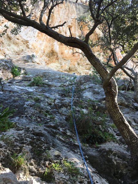 Grey Slab Right follows the rope. The climber is barely visible cleaning the anchor.