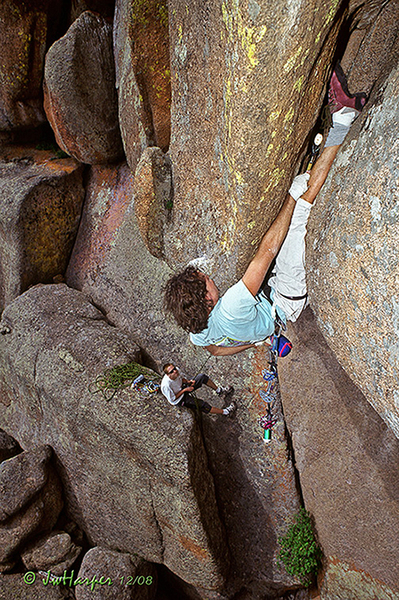 Luebben sneaking in a cam prior to climbing 'his own leg' to re-invert.