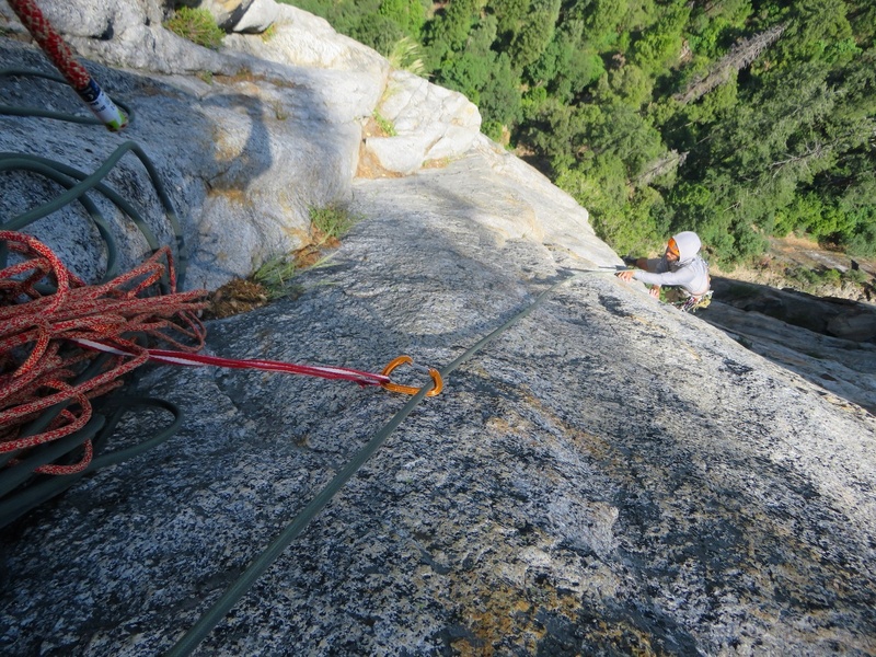 Sam on the airy traverse across the face on flakes. It is best if the leader can run it out and set the next piece about 20 feet above the traverse in order to keep the rope more above the follower. I had linked this part of the pitch with Pitch 4, so I set the belay about 20 feet above the traverse, using a #3 and #4 for the belay. The SuperTopo guide actually shows a belay here, making the route 6 pitches.