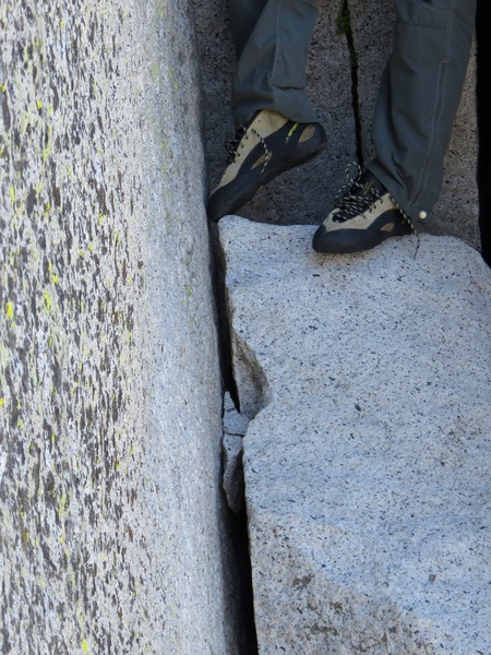 (Pitch 12 after Rockfall.) The goal is to get the knot wedged here, where Sam's toe is. Sam got it after about a dozen tries, and having watched Sam figure out the ideal technique, the leader from the party after us got it on his second toss. The rope toss eats up some time, but it is kind of fun, actually.