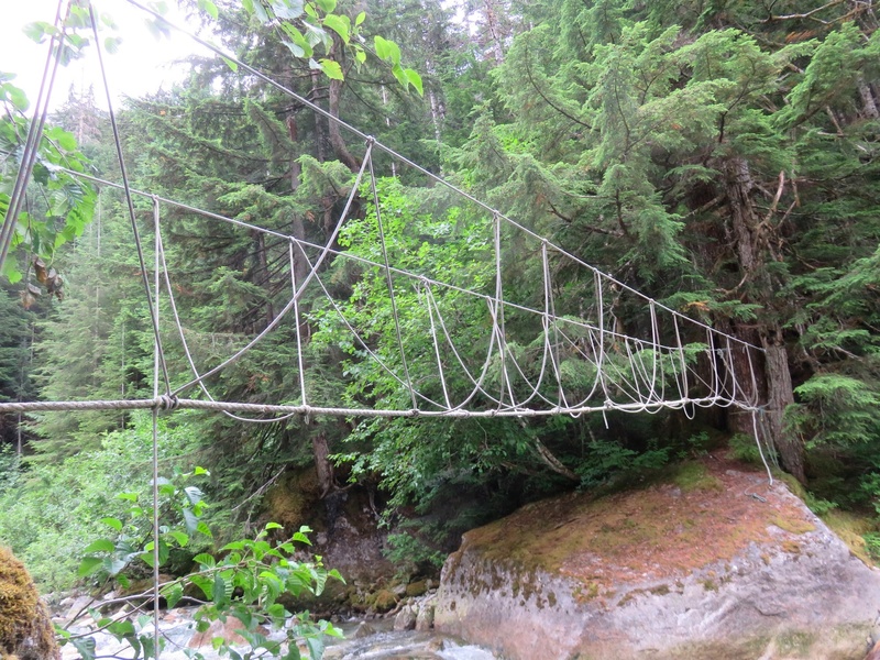 Rope bridge crossing the river between the road and the hillside leading up to Fluffy Kitten Wall.