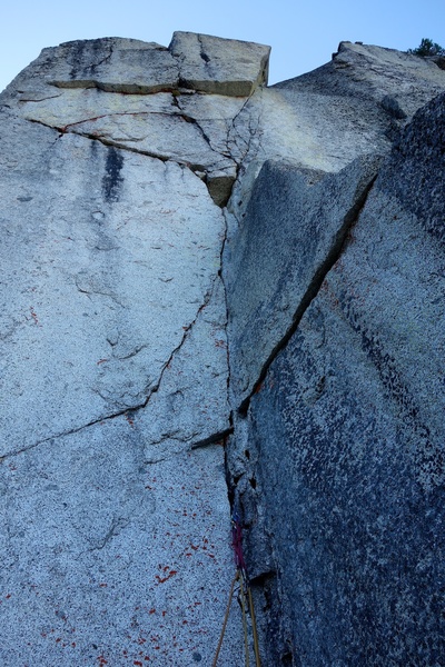 Pitch 3. 12a crux is entering the slanting fingercrack 10m from the ledge above.