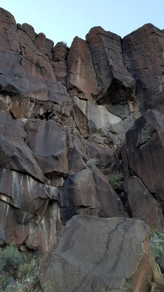 Start to the left of the boulders. Easy climbing up a low angle corner to a ledge. Follow the dihedral up to two bolt anchors right of the crack.