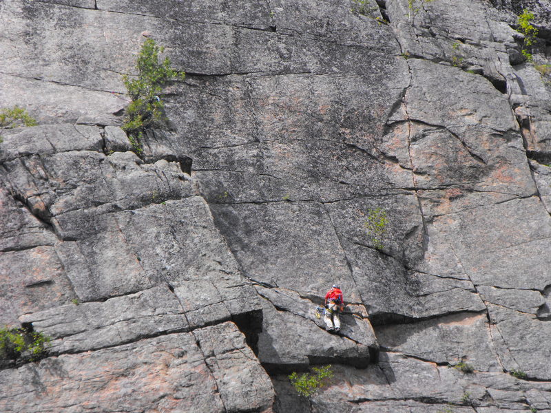 Climber approaching the end of the second pitch, (the belayer is behind the small tree). The final left leaning crack is just out of sight on the left side of pic.