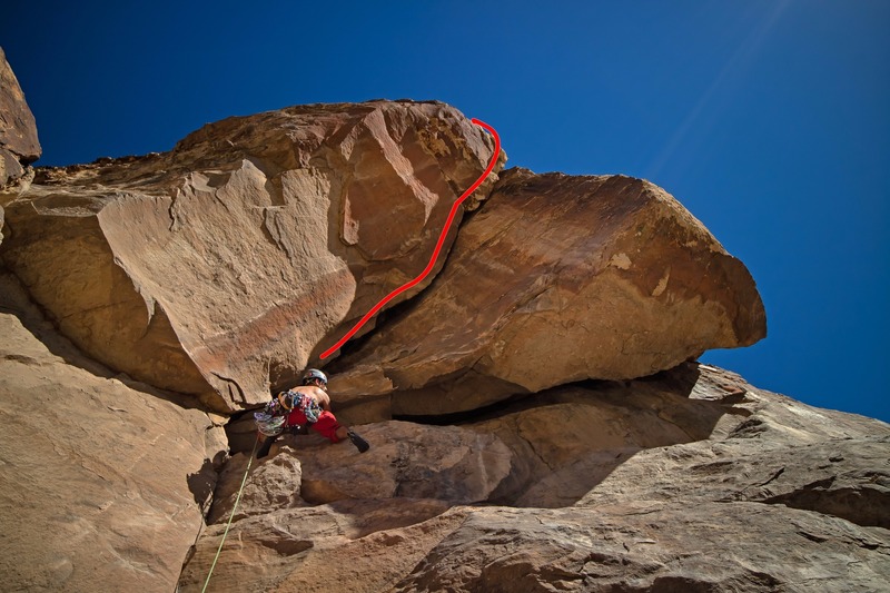 Dave climbing over the block beneath a tight squeeze opening to fire up the roof crack.