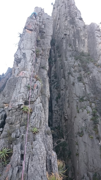 Partner climbing the crux pitch (P4) on Razorblade Ridge