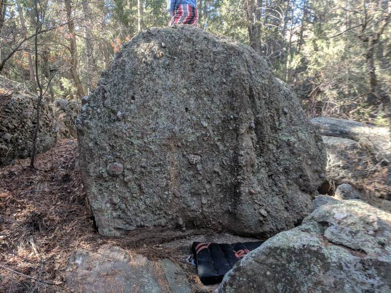 The traverse starts on the left side of the boulder face.