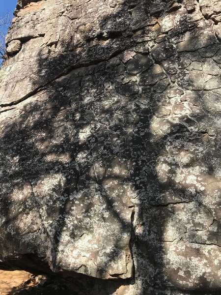 Crux starts of Playing Hooky 5.8+ and Brand New 5.8. Brand New starts on slab on right side of photo and goes straight up. Playing Hooky starts just to the left of Brand New and angles up left onto jugs.