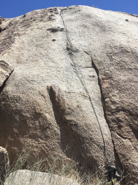 The rope more or less follows the route. Single bolt just left of the first bit of darker rock about halfway up.