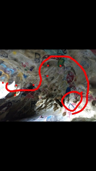 Sit start on jug in graffiti cave, move up to big painted jug above the starting one, then move to the left towards undercling tufa jugs on ceiling, swing over to rail and undercling towards the opening of cave and finish there.(v4)