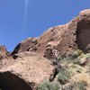 The Little Sheep Wall as seen from the river bed.  fiance for scale.  The area where you'll set up for belaying is just behind the boulder to the left of my fiance. (now called Contra Canyon Lower Wall)(and also now called my wife :3)