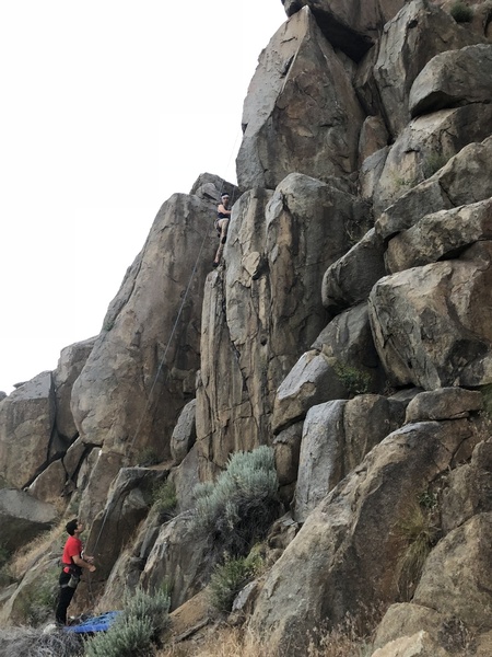 Jordan reaching the ledge before tackling the face to finish up the route