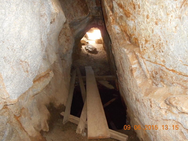 Cave entrance has a wooden plank to step over the underground spring.