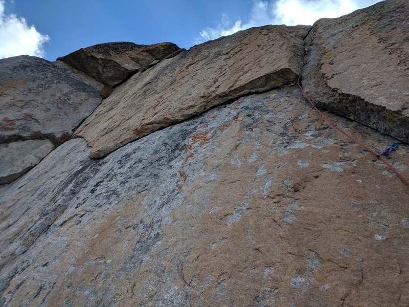A different variation to the crux on pitch 7. Left of the gold corner. Climb the corner on thin fingers through the roof, then continue up the thin, right-facing corner through a mossy jam. My partner and I both thought it was 5.10d-5.11.