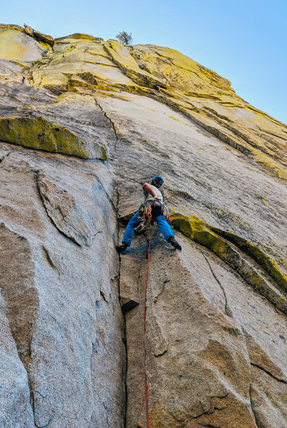 Jared W heading up pitch 1 - a thin crack, roof and left facing corner looming above
