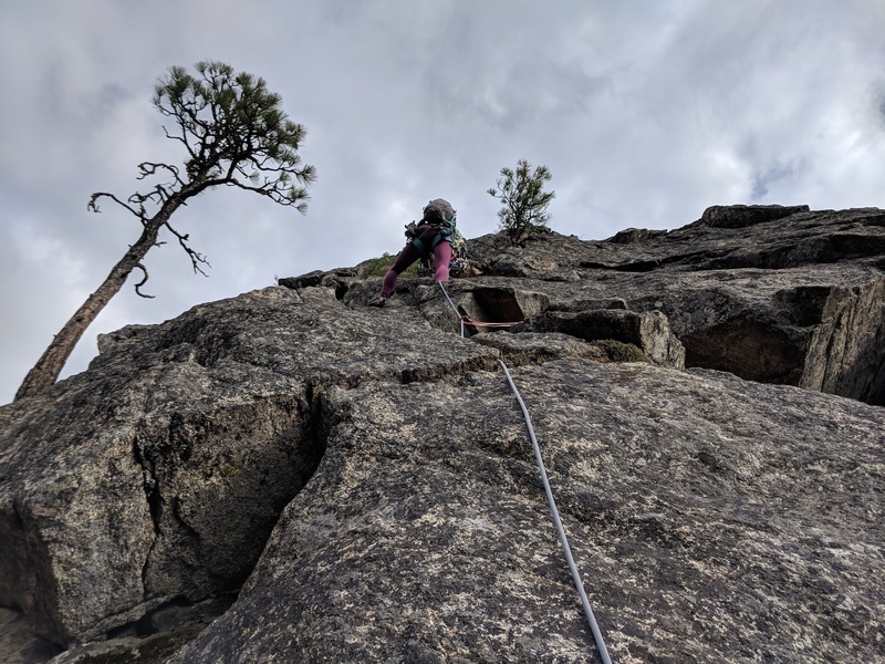 Alexis just starting the second pitch. You can follow to the left and go around the corner and then back around right above the tree (easier), or you can face climb straight up towards the tree (harder, unsure about protection, but fun on top rope)