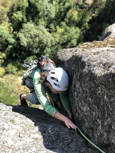 Looking down Dod's Jam; climber (Amy S.) is past the crux. Here the crack widens to #2 Camalot size and the angle eases for an easy 20' of jamming past a two bolt rap anchor to Big Ledge.