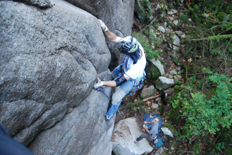 Some blurry dude belayed by another blurry dude sending a blurry climb.