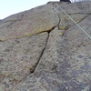 A must-do finger crack high on the east face. Pitch 2 of a nice 3-pitch line.
