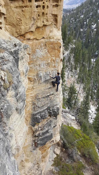 Felix, still low on the route, has traversed above the roof and is enjoying the exposure.