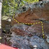 The left half of the Wave Boulder. Start in obvious hole below wave flake and go up and left to top out at high left.