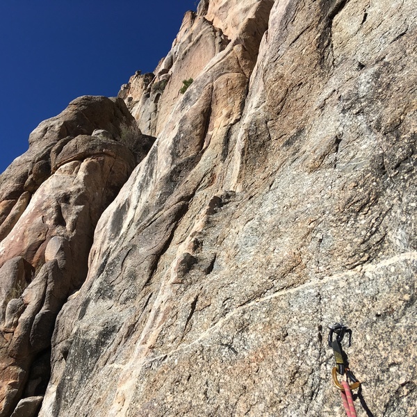 Looking up from the top of the P1 chimney out left toward the existing bolted line that you can take to the gear belay a RF, fingers dihedral. This links well from the ground with runners on the chimney gear (if any).