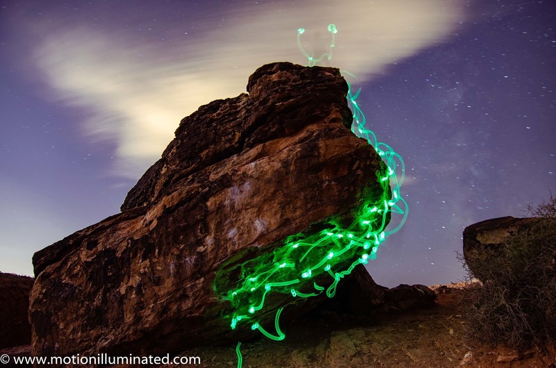 Long exposure photo. Climbing with glowsticks on hands and feet.