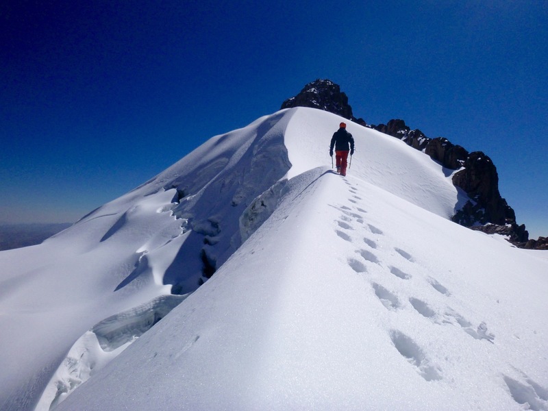Striding toward the summit block of Parcocaya after climbing the south face,