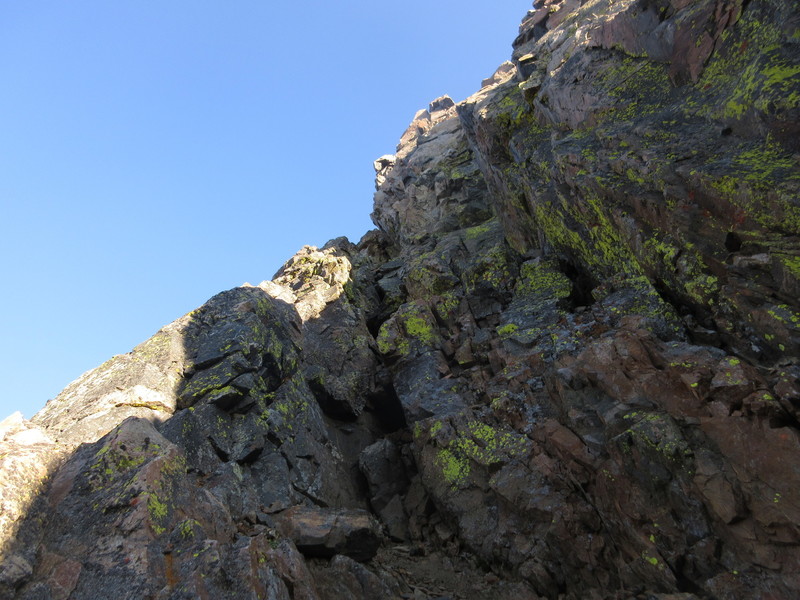 Ascending the loose and fractured chimney crux of the traverse.