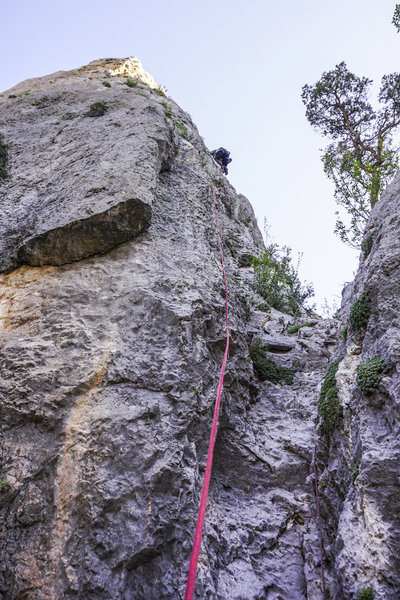 Climber on Get in There. There is a fixed rope on the right that ascends the approach gully into The Abyss.