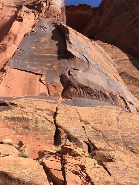 The belay bolt is visible in the panel of varnish at the base of the crack proper.