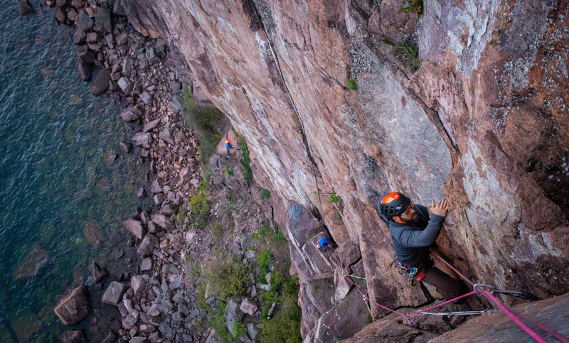 climber in blue at belay ledge below and climber in grey finishing up second pitch