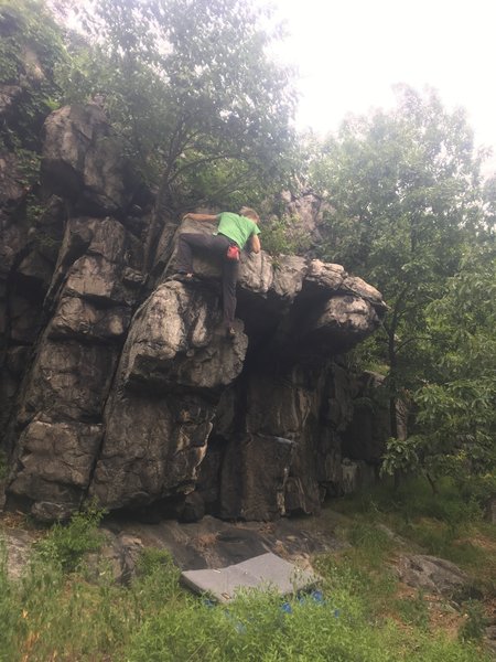 climber finishing Hog Maw. Came from down and right around corner in dihedral. Climbers is preparing to mantle the top out.