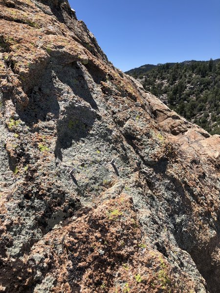 Possibly where the rap anchor used to be on the back side of the summit? The scramble down to the saddle is not too difficult without it.