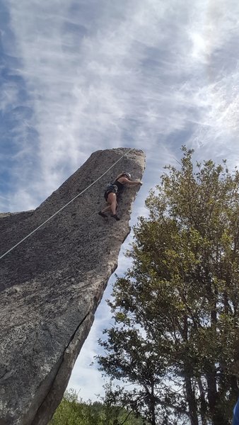 Climber near the sole bolt on the arete