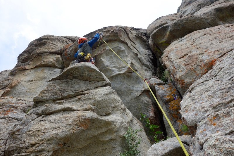 Clipping the bolt that protects the crux move.