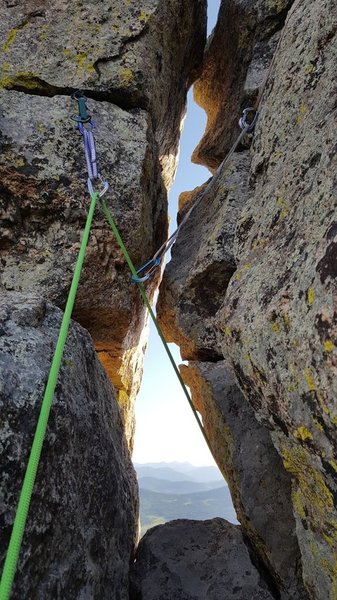 This probably isn't on the actual route, but idk. After the twin cracks section, I went up the ramp to the right, up a 4" wide crack, then up and through stacks of blocks on top. This is the wormhole. I had to take my shoes off my harness to fit through.