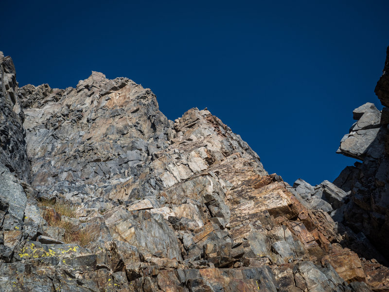 In the approach gully right above the chock stone. If you want to cut out some roped climbing, continue up and to the left to the end of the gully until you meet the ridge where you rope up and climb to rejoin the main route.