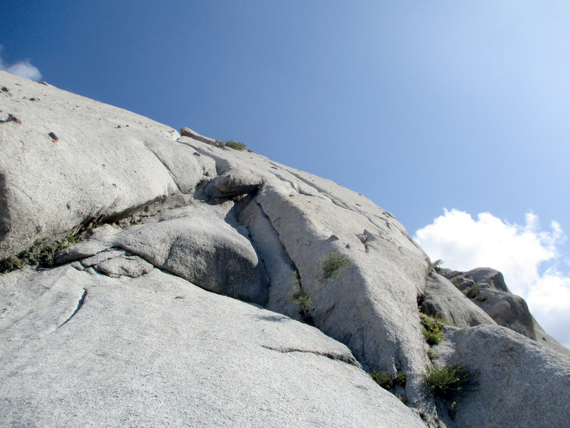Fun start and first crux of P6. Easy hand crack leads to slab & stemming into the left groove, with another jog left before the anchors. The P7 5.7 chimney is on the horizon.