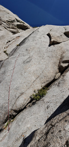 P3 seen from the base. Unfortunately the old aid line is no longer any good, as the tat to reach the right corner TT is old and shortened, and the bolt looked bad. There is a piton on the left of the ledge protecting the entry mantle into the crack.