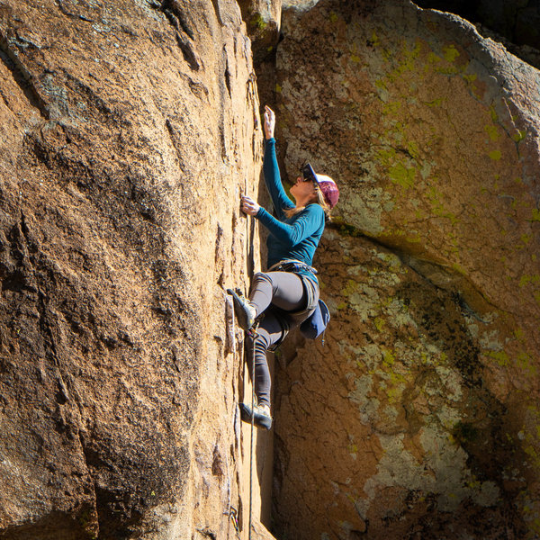 Natalie reaches as she crimps past the crux and sends her first 11a