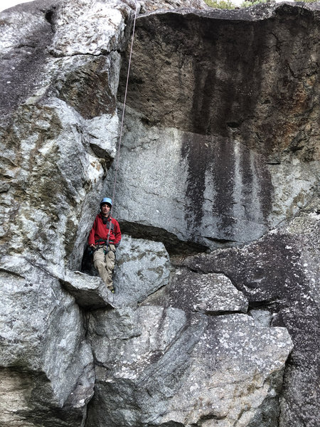 Conner Kranz on ledge before climbing the dihedral hand crack to pull the roof.