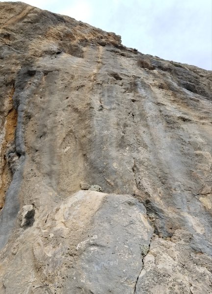 Myticon heads through steep terrain at the right edge of the overhanging wall.