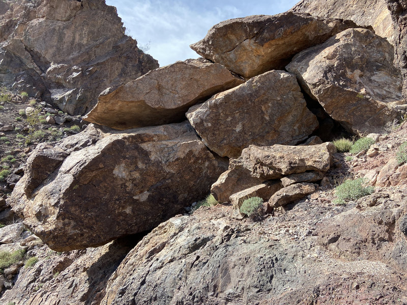 The east side of the stack of rocks on the hillside below the crag.
