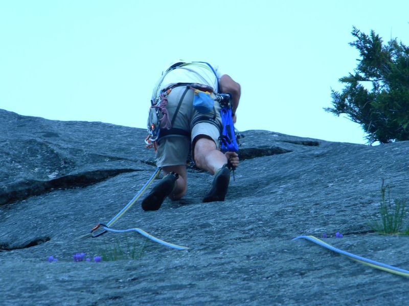 Bill Enger drilling the bolt protecting the crux of Pitch 1 from a stance on the angled dike